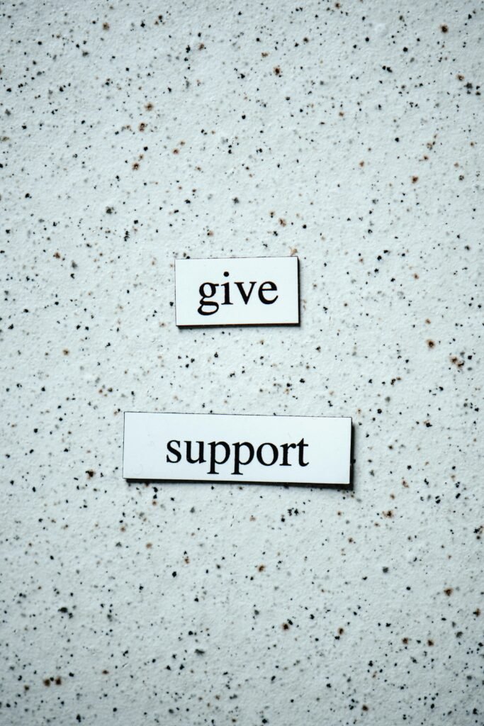 Text saying 'give support' on a textured surface, promoting encouragement.